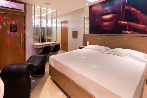 una camera da letto con un grande letto bianco e uno specchio di Uno Prime Motel - Aricanduva a San Paolo