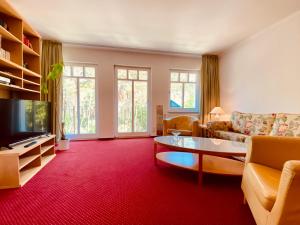 a living room with a couch and a tv at Haus Kastell - Suite Strandglück in Ahlbeck