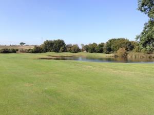 a golf course with a view of a lake at Green house Marco Simone Golf Club in Marco Simone