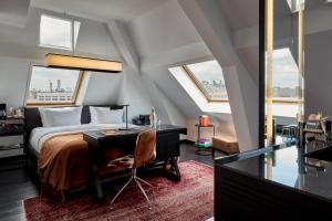a bedroom with a bed and a desk and windows at Sir Albert Hotel in Amsterdam