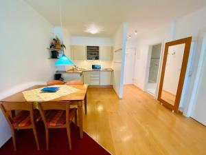 a kitchen and dining room with a wooden table and chairs at Haus Kastell - Suite Strandglück in Ahlbeck
