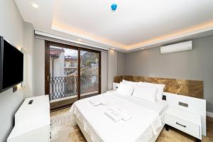 a bedroom with a white bed and a large window at Sea View Flat with Hot Tub in Antalya Kas in Kas