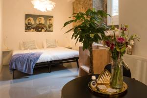 a room with a bed and a table with flowers at Hotel Zilt Studio's in Vlissingen