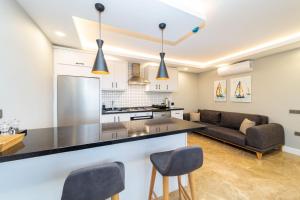 a kitchen and living room with a counter and chairs at Flat with Jacuzzi and Sea View in Kas Antalya in Kas