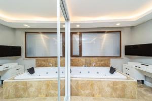 a large bathroom with two sinks and a tub at Flat with Jacuzzi and Sea View in Kas Antalya in Kas