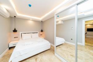 a bedroom with a bed and a mirror at Flat with Jacuzzi and Sea View in Kas Antalya in Kas