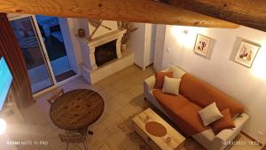 vistas panorámicas a una sala de estar con sofá y chimenea en L' ecurie de Florent et Spa, en Cheval Blanc