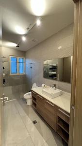 a bathroom with a sink and a toilet and a mirror at AmazINN Places Playa Escondida SeaView in María Chiquita