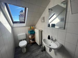 een badkamer met een wastafel, een toilet en een raam bij FeWo an der Göltzschtalbrücke in Netzschkau