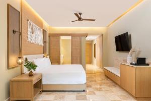 a bedroom with a white bed and a tv at Hyatt Zilara Riviera Maya Adults Only All-Inclusive in Playa del Carmen