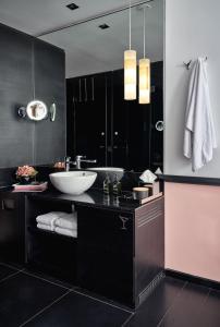 a black bathroom with a sink and a mirror at Sir Albert Hotel, part of Sircle Collection in Amsterdam