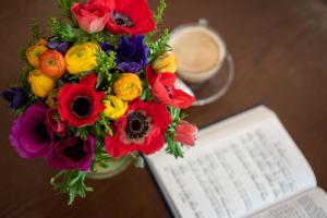 a vase filled with flowers next to a book at Prima Palace Hotel in Jerusalem