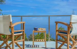 2 sillas y una mesa en un balcón con vistas al océano en DN Beach Coast Villa, en Skinária