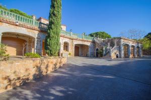 een groot huis met een stenen muur en een oprit bij Club Villamar - La Gamba in Sant Feliu de Guixols