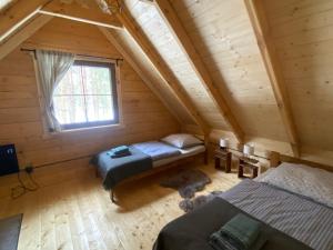 um quarto no sótão com 2 camas e uma janela em FoRest Inn em Trzepieciny