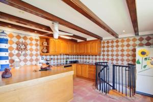 cocina con armarios de madera y nevera blanca en Club Villamar - Apartment Las Vegas, en Sant Antoni de Calonge