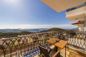 a balcony with a wooden table and chairs at Fully Furnished Flat with Sea View in Kas Antalya in Kas