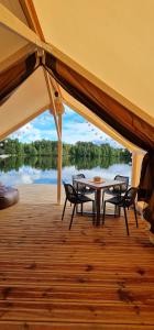 a patio with a table and chairs on a boat at BB camping in Liepāja