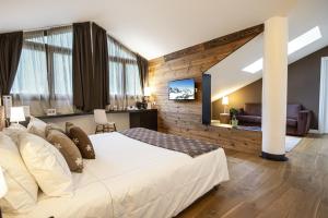 um quarto com uma grande cama branca num quarto em Montana Lodge & Spa, by R Collection Hotels em La Thuile