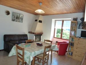 sala de estar con mesa, sillas y sofá en La Grange, en Condamine-Châtelard