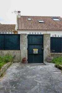 uma casa com um portão preto e uma entrada em Quintinha a 35min de Lisboa em Mafra