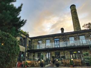 een gebouw met tafels en stoelen ervoor bij The Weavers Shed in Huddersfield