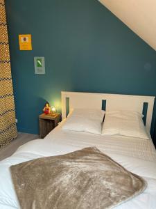 ein Schlafzimmer mit einem weißen Bett und einer blauen Wand in der Unterkunft La Maison de Fanny in Vineuil
