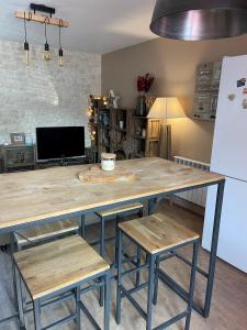 eine Küche mit einem großen Holztisch und 2 Stühlen in der Unterkunft La Maison de Fanny in Vineuil