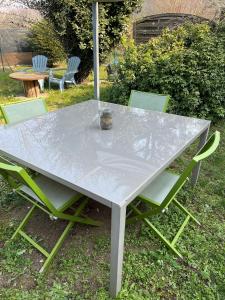 einen Tisch mit 2 Stühlen und einem Sonnenschirm in der Unterkunft La Maison de Fanny in Vineuil