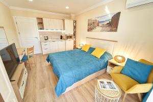 1 dormitorio con 1 cama azul y cocina en Burgas Beach Resort Apartments en Burgas