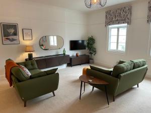 a living room with two couches and a tv at Victoria Apartment 2 in Torquay