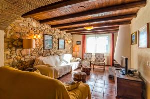 ein Wohnzimmer mit einem Sofa und einer Steinmauer in der Unterkunft Club Villamar - Can Metlla in Sils