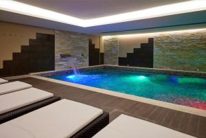 a swimming pool with a waterfall in a house at Blu Hotel Acquaseria in Ponte di Legno