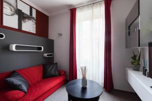 salon z czerwoną kanapą i oknem w obiekcie Attic Vatican Flat - San Pietro w Rzymie