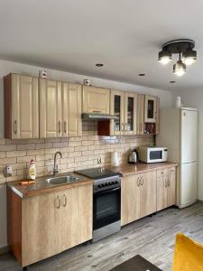 a kitchen with wooden cabinets and a white refrigerator at Dom wypoczynkowy FENIX in Werblinia
