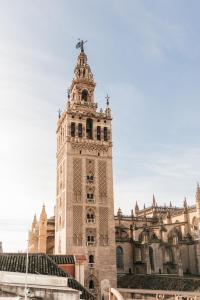 una torre de reloj frente a un edificio en Casa ART Sevilla, en Sevilla