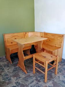 a wooden table and a bench with a table and a table and stool at Lo de Facu in Puerto Pirámides