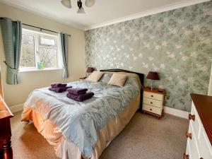 ChettonにあるDamson Lodgeのベッドルーム1室(紫色のタオルが付いたベッド1台付)