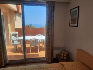 a bedroom with a balcony with a table and chairs at Le Golfe bleu in Roquebrune-Cap-Martin
