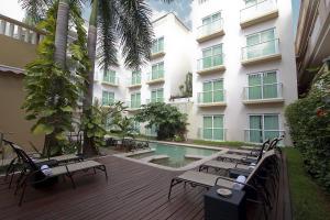 a hotel with a deck with chairs and a swimming pool at Wyndham Merida in Mérida