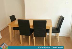 a wooden table with four black chairs around it at Leigh Accommodation in Leigh