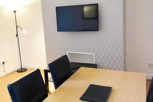 a conference room with a table and a television on a wall at Leigh Accommodation in Leigh