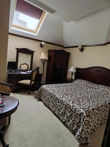 a bedroom with a bed and a table and a mirror at Hotel Carol in Constanţa