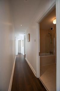 a hallway of a bathroom with a shower and a tub at Grand Canal District Apartments in Dublin +46 photos