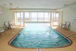 a large swimming pool in a building with chairs at Tradewinds 808 - NEW Rental- 1bd/2bath-Luxury Comfort in Orange Beach