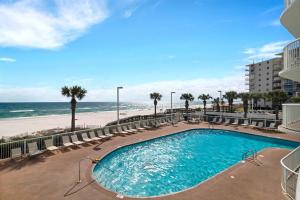 a swimming pool with chairs and a beach at Tradewinds 808 - NEW Rental- 1bd/2bath-Luxury Comfort in Orange Beach