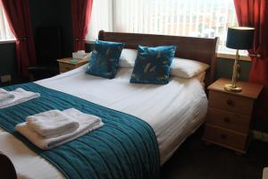 um quarto com uma cama com toalhas em Waverley B & B em Minehead