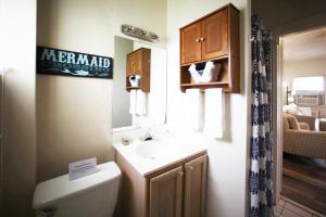 y baño con lavabo, aseo y espejo. en 510 A The Beach Break Bungalow, en Virginia Beach