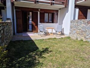 a patio with two chairs and a table in front of a house at Casetta Loretta in San Pietro