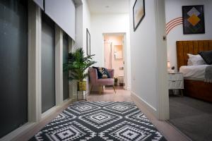 a hallway with a bedroom with a bed and a rug at Spacious Luxury Apartment in Stevenage, Sleeps 6, with Free Parking, and Free Wi-Fi in Stevenage